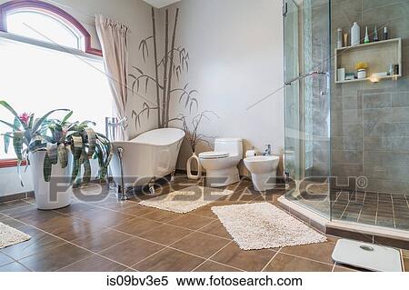 Free standing bathtub, bidet, clear glass shower stall in ensuite, grey nuanced ceramic tile floor View Large Photo Image Stock Photography - Free standing bathtub, bidet, clear glass shower stall in ensuite, grey nuanced ceramic tile floor. Fotosearch