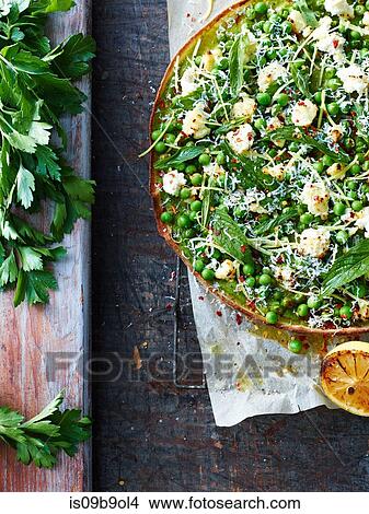 Picture - Fresh green pea and salad leaf pizza, overhead view. Fotosearch