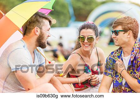 Stock Image - Friends at festival chatting, smiling. Fotosearch