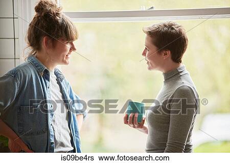 Stock Photograph - Friends chatting in kitchen. Fotosearch