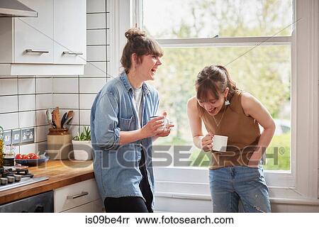 Stock Photography - Friends chatting in kitchen. Fotosearch