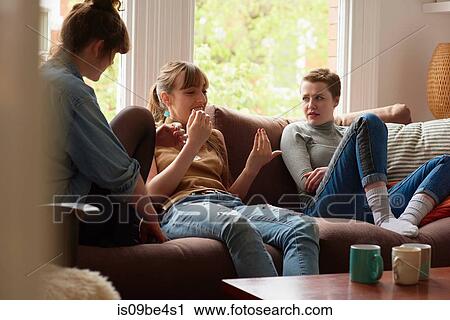 Stock Image - Friends chatting on sofa. Fotosearch