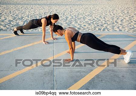 Friends doing exercises by beach View Large Photo Image Stock Photography - Friends doing exercises by beach. Fotosearch