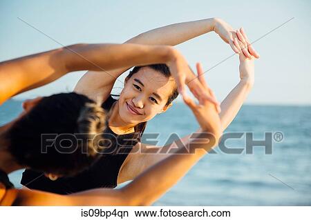Friends doing exercises on beach View Large Photo Image Picture - Friends doing exercises on beach. Fotosearch