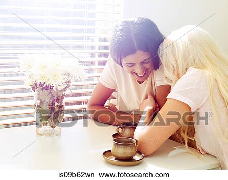 Friends having coffee together laughing View Large Photo Image Picture - Friends having coffee together laughing. Fotosearch