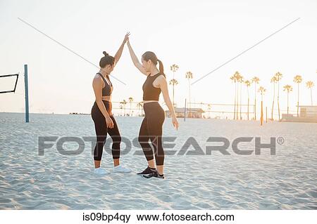 Friends hi fiving on beach, Long Beach, California, US View Large Photo Image Stock Photo - Friends hi fiving on beach, Long Beach, California, US. Fotosearch