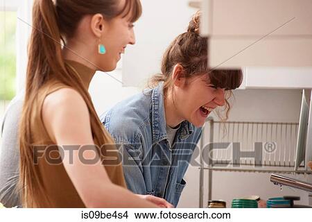 Friends laughing in kitchen View Large Photo Image Picture - Friends laughing in kitchen. Fotosearch