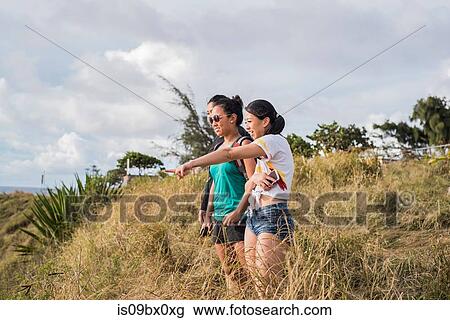 Stock Image - Friends looking down to Hookipa Beach, Maui, Hawaii. Fotosearch