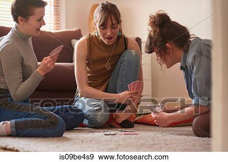 Friends playing cards in living room View Large Photo Image Stock Photo - Friends playing cards in living room. Fotosearch
