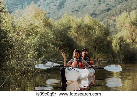 Stock Photography - Friends taking break, showing peace sign in kayak, Kaweah, California, United States. Fotosearch