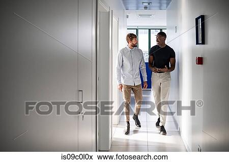 Friends talking and walking on corridor in hospital View Large Photo Image Stock Photo - Friends talking and walking on corridor in hospital. Fotosearch