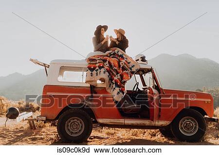 Friends toasting on rooftop of off road vehicle, Kennedy Meadows, California, US View Large Photo Image Stock Image - Friends toasting on rooftop of off road vehicle, Kennedy Meadows, California, US. Fotosearch