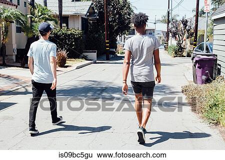 Stock Photograph - Friends walking down sunny street, Long Beach, California, US. Fotosearch