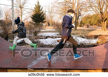 Girl and brother running in opposite directions on rural skateboard ramp View Large Photo Image Stock Photograph - Girl and brother running in opposite directions on rural skateboard ramp. Fotosearch