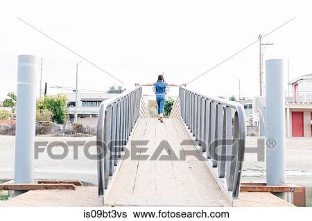 Stock Photograph - Girl crossing bridge, Long Beach, California, US. Fotosearch