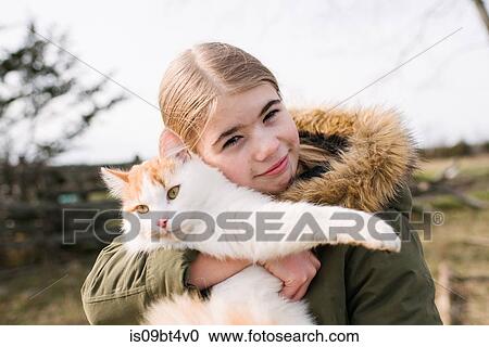 Girl cuddling cat in field View Large Photo Image Stock Image - Girl cuddling cat in field. Fotosearch