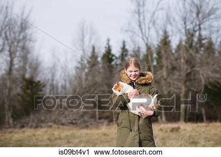Girl cuddling cat in field View Large Photo Image Stock Image - Girl cuddling cat in field. Fotosearch