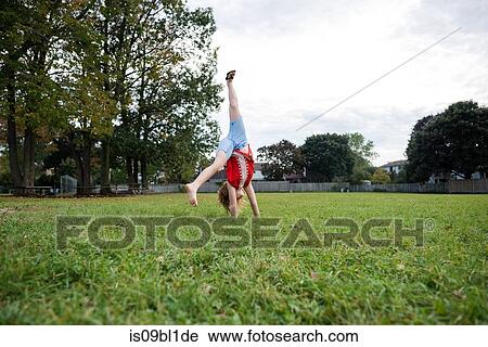 Girl doing cartwheel in park View Large Photo Image Stock Image - Girl doing cartwheel in park. Fotosearch