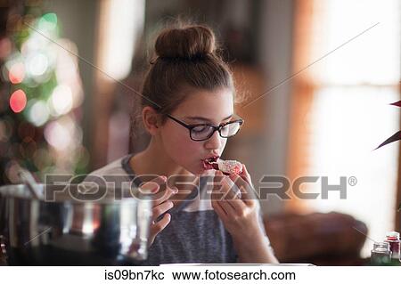 Girl eating her homemade christmas cookie at kitchen counter View Large Photo Image Stock Image - Girl eating her homemade christmas cookie at kitchen counter. Fotosearch