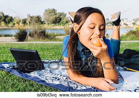 Stock Photography - Girl enjoying apple, Long Beach, California, US. Fotosearch