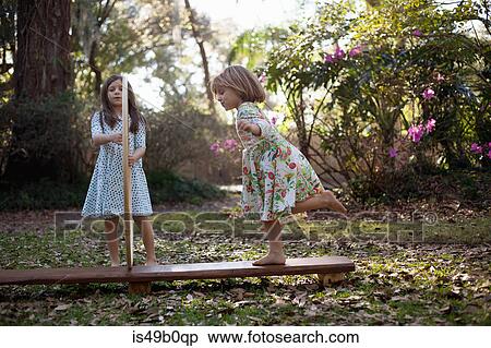Stock Photography - Girl holding plastic hoops with sister running through. Fotosearch
