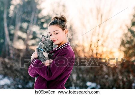 Girl hugging french bulldog puppy outdoors View Large Photo Image Picture - Girl hugging french bulldog puppy outdoors. Fotosearch