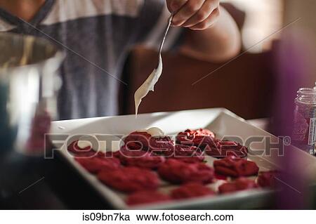 Girl icing a tray of christmas cookies at kitchen counter, close up mid section View Large Photo Image Stock Image - Girl icing a tray of christmas cookies at kitchen counter, close up mid section. Fotosearch