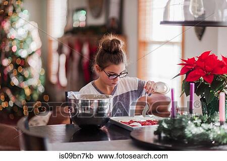 Stock Image - Girl icing christmas cookies. Fotosearch