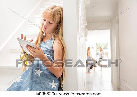 Girl in hallway using digital tablet View Large Photo Image Stock Photograph - Girl in hallway using digital tablet. Fotosearch