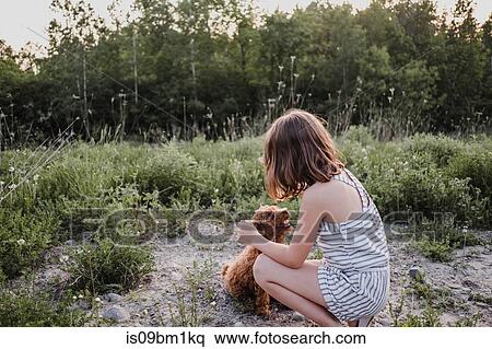 Girl kneeling to train puppy View Large Photo Image Stock Photography - Girl kneeling to train puppy. Fotosearch