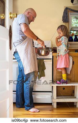 Girl on stool watching father whisking food in kitchen View Large Photo Image Stock Photography - Girl on stool watching father whisking food in kitchen. Fotosearch