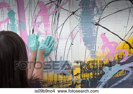 Picture - Girl painting wall with hands. Fotosearch