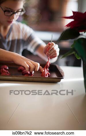 Girl placing christmas cookie dough onto baking tray at kitchen counter View Large Photo Image Stock Image - Girl placing christmas cookie dough onto baking tray at kitchen counter. Fotosearch