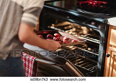 Girl placing tray of christmas cookies into oven, mid section View Large Photo Image Stock Image - Girl placing tray of christmas cookies into oven, mid section. Fotosearch