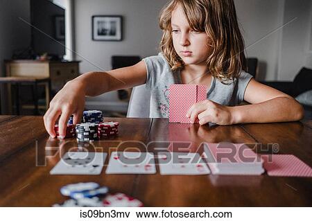 Stock Photo - Girl playing cards at table, stacking gambling chips. Fotosearch
