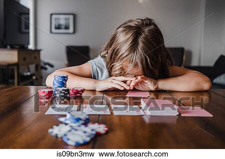 Girl playing cards at table with head down View Large Photo Image Stock Photo - Girl playing cards at table with head down. Fotosearch