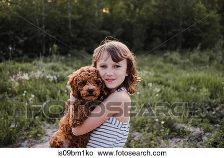 Girl posing with puppy in her arms View Large Photo Image Picture - Girl posing with puppy in her arms. Fotosearch