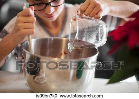 Girl pouring egg white into mixing bowl for christmas cookies at kitchen counter, close up View Large Photo Image Stock Image - Girl pouring egg white into mixing bowl for christmas cookies at kitchen counter, close up. Fotosearch