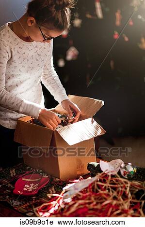 Stock Image - Girl putting up Christmas decorations. Fotosearch