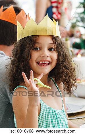 Stock Photo - Girl wearing paper crown at home party. Fotosearch