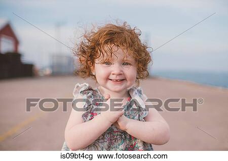 Girl with curly red hair at coast, portrait View Large Photo Image Stock Image - Girl with curly red hair at coast, portrait. Fotosearch