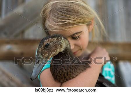 Girl with eyes closed hugging farm duck View Large Photo Image Stock Photo - Girl with eyes closed hugging farm duck. Fotosearch