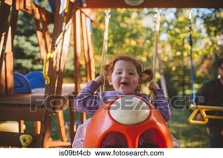 Girl with red hair swinging on playground swing, portrait View Large Photo Image Stock Image - Girl with red hair swinging on playground swing, portrait. Fotosearch