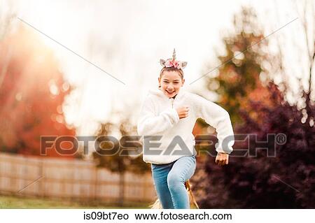 Girl with unicorn hairband running in park View Large Photo Image Picture - Girl with unicorn hairband running in park. Fotosearch