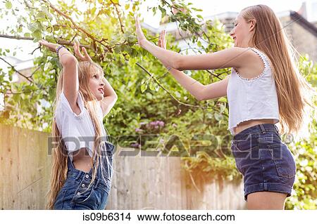 Girls in garden playing pat a cake View Large Photo Image Picture - Girls in garden playing pat a cake. Fotosearch