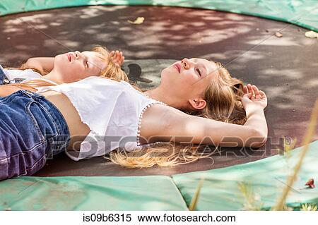 Girls lying down on trampoline View Large Photo Image Stock Photography - Girls lying down on trampoline. Fotosearch