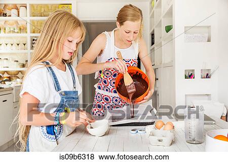 Girls preparing chocolate brownies in kitchen View Large Photo Image Stock Photo - Girls preparing chocolate brownies in kitchen. Fotosearch