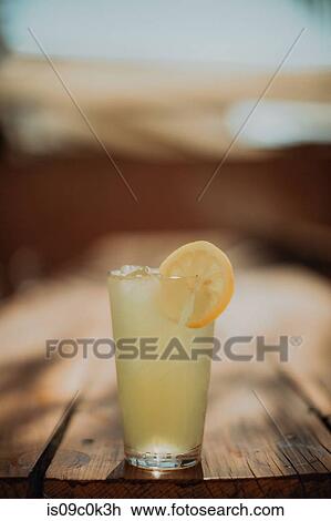Glass of iced lemon fruit drink on cafe table, shallow focus View Large Photo Image Stock Image - Glass of iced lemon fruit drink on cafe table, shallow focus. Fotosearch