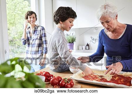 Grandmother and grandson making pizza in kitchen, mother in background using smartphone View Large Photo Image Stock Image - Grandmother and grandson making pizza in kitchen, mother in background using smartphone. Fotosearch