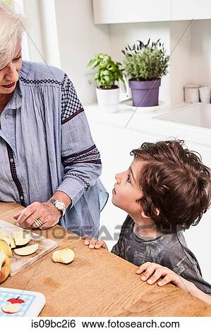 Grandmother and grandson preparing food in kitchen, grandson with questioning expression View Large Photo Image Stock Photograph - Grandmother and grandson preparing food in kitchen, grandson with questioning expression. Fotosearch